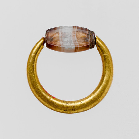 Gold swivel ring with agate scaraboid featuring two seated roaring lions with a plant between them (Cypriot or Phoenician circa 6th-5th century BCE)